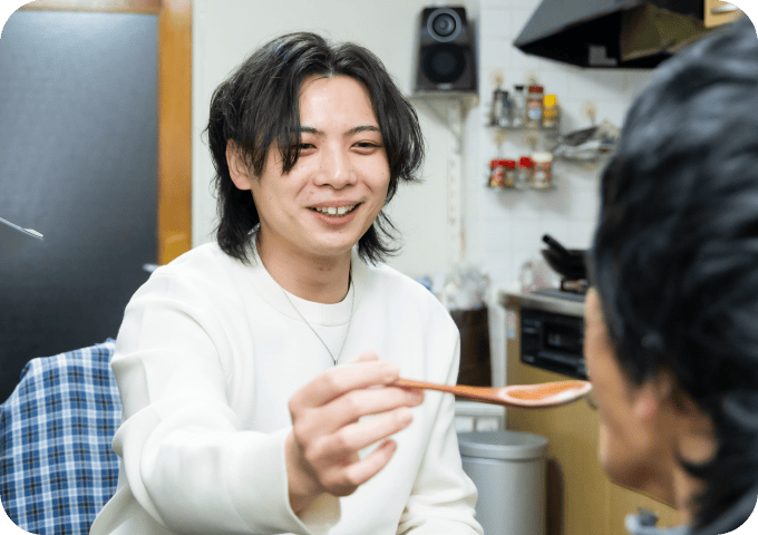 被介護者と介護士が笑顔で食事しているシーン