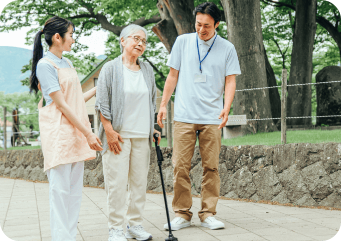 介護士二人と被介護者が散歩しているシーン
